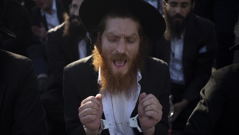 Pasukan keamanan beroperasi ketika para pria Yahudi Ultra-Ortodoks melakukan protes setelah Mahkamah Agung Israel bersidang untuk membahas petisi guna mengubah kebijakan pemerintah yang memberikan pengecualian kepada orang-orang Yahudi ultra-Ortodoks dari wajib militer, di tengah konflik yang sedang berlangsung di Gaza antara Israel dan kelompok Islam Palestina Hamas, dekat dengan Mahkamah Agung Israel. Pengadilan di Yerusalem, 2 Juni 2024. (REUTERS/Ronen Zvulun)