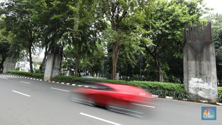 Sejumlah kendaraan melintas di antara tiang monorel yang terhenti pembangunannya di Jalan Rasuna Said, Jakarta, Senin (3/6/2024). (CNBC Indonesia/Tri Susilo)