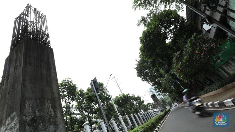 Sejumlah kendaraan melintas di antara tiang monorel yang terhenti pembangunannya di Jalan Rasuna Said, Jakarta, Senin (3/6/2024). (CNBC Indonesia/Tri Susilo)