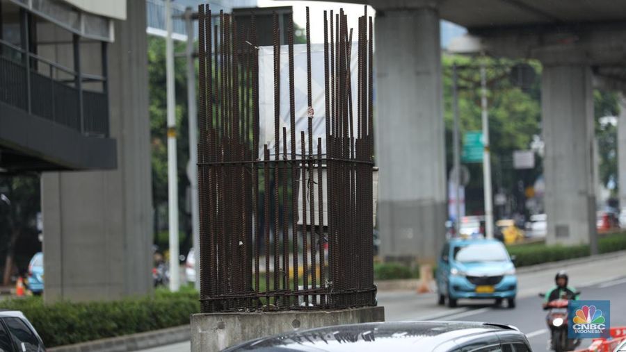 Sejumlah kendaraan melintas di antara tiang monorel yang terhenti pembangunannya di Jalan Rasuna Said, Jakarta, Senin (3/6/2024). (CNBC Indonesia/Tri Susilo)