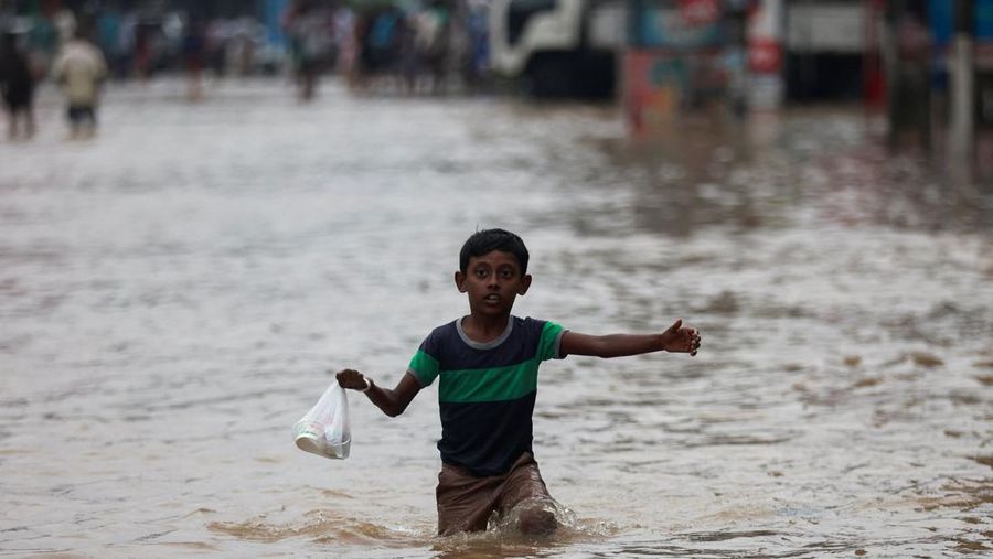 Penduduk desa berjalan melalui jalan yang banjir di Biyagama, Sri Lanka 2 Juni 2024. (REUTERS/Dinuka Liyanawatte)