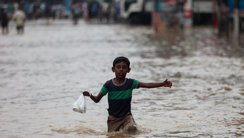 Penduduk desa berjalan melalui jalan yang banjir di Biyagama, Sri Lanka 2 Juni 2024. (REUTERS/Dinuka Liyanawatte)