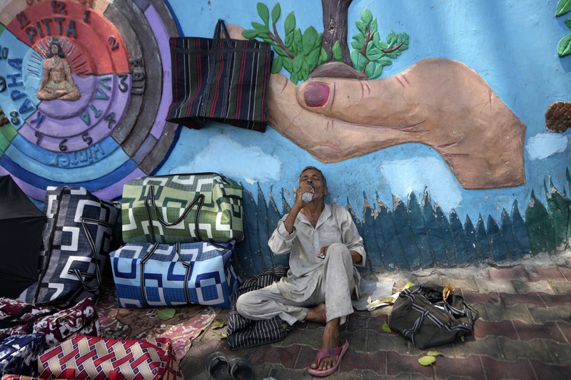 Seorang pria menggendong seorang anak dengan kepala ditutupi handuk untuk melindunginya dari panas di Jammu, India, Minggu, 2 Juni 2024. Seorang pria menggendong seorang anak dengan kepala ditutupi handuk untuk melindunginya dari panas di Jammu, India, Minggu, 2 Juni 2024. (AP Photo/Channi Anand)