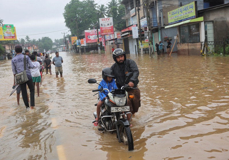 Penduduk desa berjalan melalui jalan yang banjir di Biyagama, Sri Lanka 2 Juni 2024. (REUTERS/Dinuka Liyanawatte)