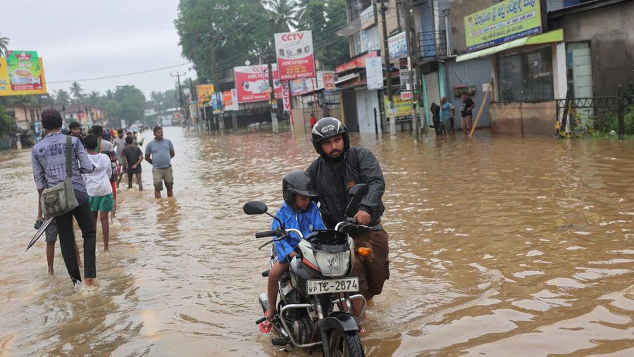Penduduk desa berjalan melalui jalan yang banjir di Biyagama, Sri Lanka 2 Juni 2024. (REUTERS/Dinuka Liyanawatte)