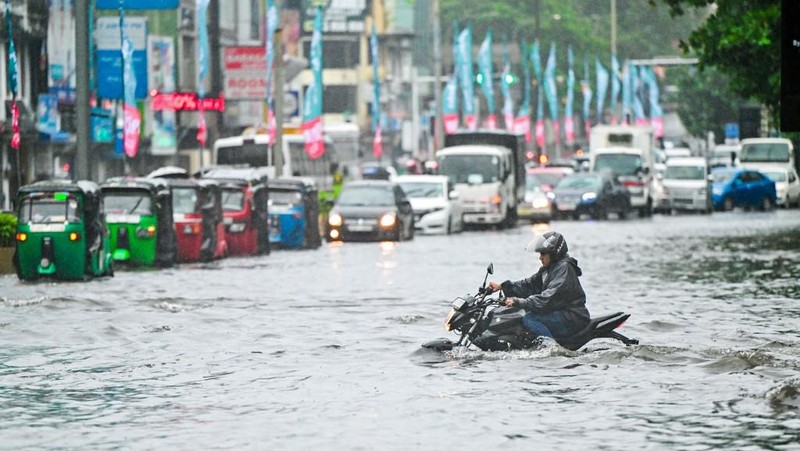 Penduduk desa berjalan melalui jalan yang banjir di Biyagama, Sri Lanka 2 Juni 2024. (REUTERS/Dinuka Liyanawatte)
