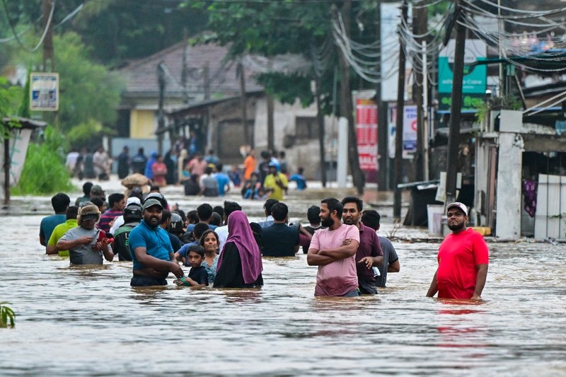 Penduduk desa berjalan melalui jalan yang banjir di Biyagama, Sri Lanka 2 Juni 2024. Penduduk desa berjalan melalui jalan yang banjir di Biyagama, Sri Lanka 2 Juni 2024. (REUTERS/Dinuka Liyanawatte)