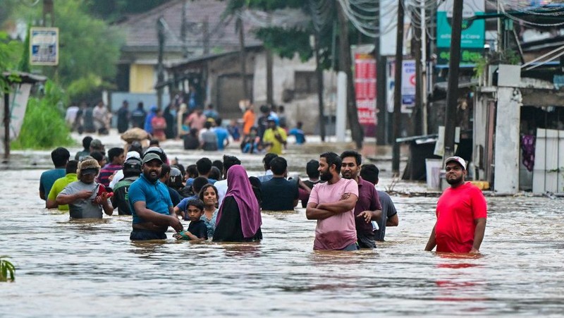 Penduduk desa berjalan melalui jalan yang banjir di Biyagama, Sri Lanka 2 Juni 2024. (REUTERS/Dinuka Liyanawatte)