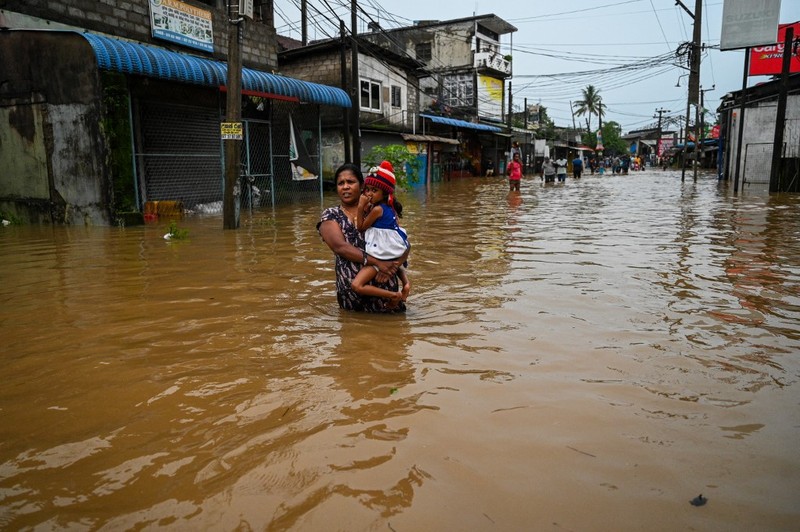 Penduduk desa berjalan melalui jalan yang banjir di Biyagama, Sri Lanka 2 Juni 2024. Penduduk desa berjalan melalui jalan yang banjir di Biyagama, Sri Lanka 2 Juni 2024. (REUTERS/Dinuka Liyanawatte)