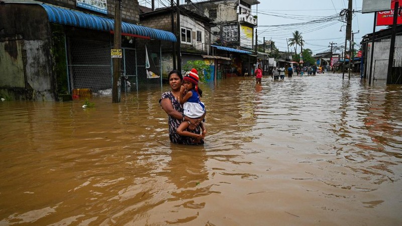 Penduduk desa berjalan melalui jalan yang banjir di Biyagama, Sri Lanka 2 Juni 2024. (REUTERS/Dinuka Liyanawatte)