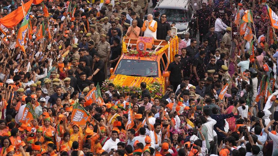 FILE - Indian Prime Minister Narendra Modi, in a white waistcoat, greets supporters from a vehicle during a roadshow in Varanasi, India, on May 13, 2024. Modi swept to power a decade ago on promises to transform India's economy, and It would be hard to argue he hasn't made strides. As he seeks a third term as prime minister, the country's economic growth is the envy of the world, its stock markets are booming, and new buildings and highways are popping up everywhere. (AP Photo/Rajesh Kumar, File)