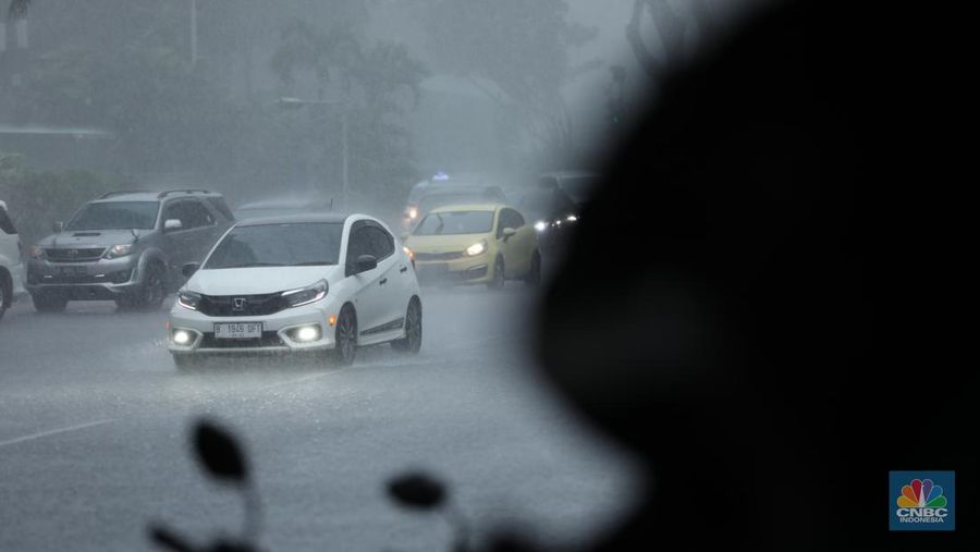 Sejumlah pengendara berteduh saat hujan deras dan angin kencang di kawasan Sudirman, Jakarta, Selasa (4/6/2024). (CNBC Indonesia/Tri Susilo)
