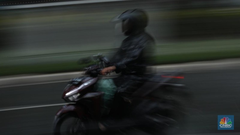 Sejumlah pengendara berteduh saat hujan deras dan angin kencang di kawasan Sudirman, Jakarta, Selasa (4/6/2024). (CNBC Indonesia/Tri Susilo)