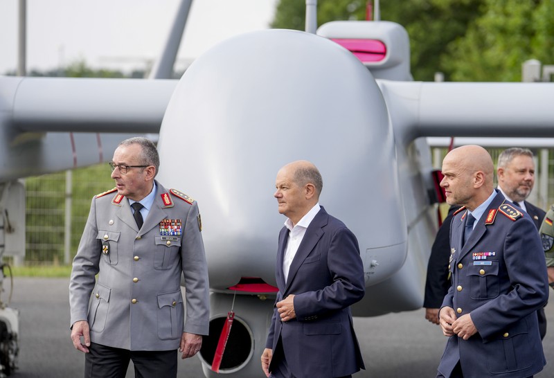 Kanselir Jerman Olaf Scholz, tengah, berjalan melewati drone Heron TP di International Air Show ILA di Berlin, Jerman, Rabu, 5 Juni 2024. (AP Photo/Ebrahim Noroozi)