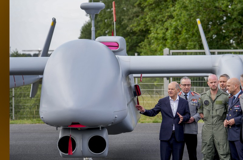 Kanselir Jerman Olaf Scholz, tengah, berjalan melewati drone Heron TP di International Air Show ILA di Berlin, Jerman, Rabu, 5 Juni 2024. (AP Photo/Ebrahim Noroozi)