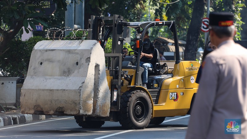 Petugas memindahkan barier beton menggunakan alat berat untuk penutupan ruas jalan di kawasan Jalan Medan Merdeka Barat, Jakarta, Kamis (6/6/2024). (CNBC Indonesia/Faisal Rahman)