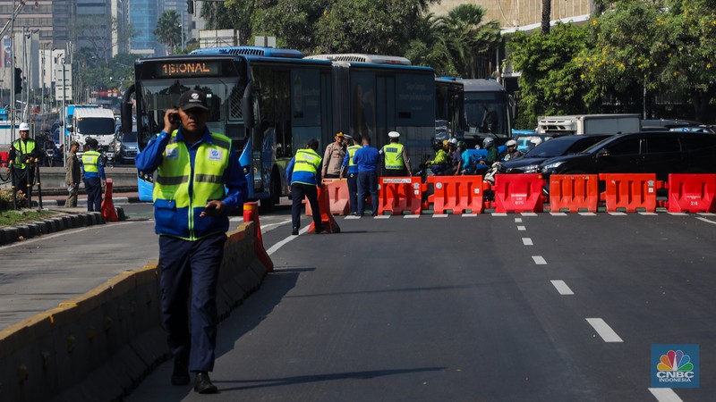 Petugas memindahkan barier beton menggunakan alat berat untuk penutupan ruas jalan di kawasan Jalan Medan Merdeka Barat, Jakarta, Kamis (6/6/2024). (CNBC Indonesia/Faisal Rahman)