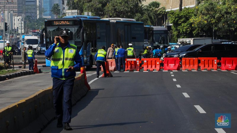 Petugas memindahkan barier beton menggunakan alat berat untuk penutupan ruas jalan di kawasan Jalan Medan Merdeka Barat, Jakarta, Kamis (6/6/2024). (CNBC Indonesia/Faisal Rahman)