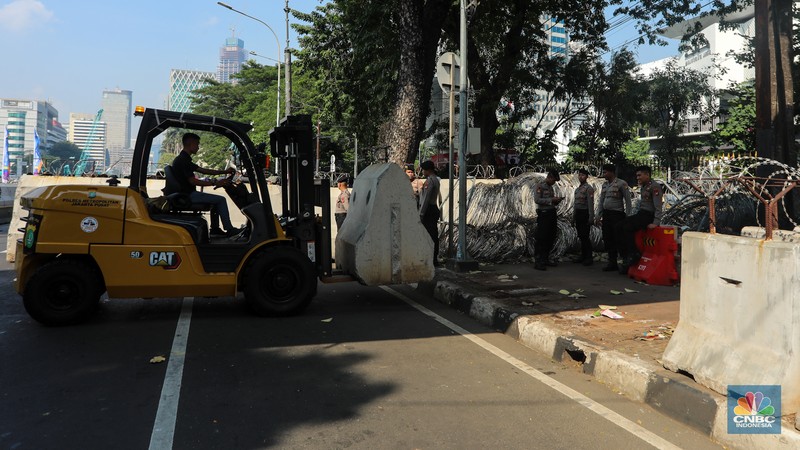Petugas memindahkan barier beton menggunakan alat berat untuk penutupan ruas jalan di kawasan Jalan Medan Merdeka Barat, Jakarta, Kamis (6/6/2024). (CNBC Indonesia/Faisal Rahman)