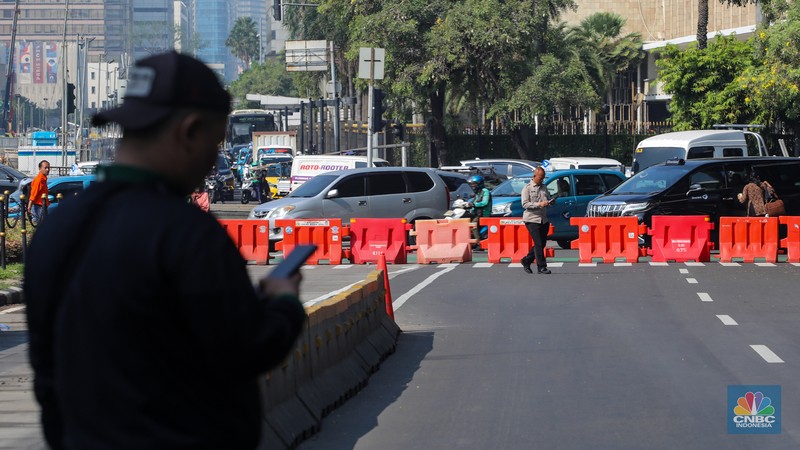 Petugas memindahkan barier beton menggunakan alat berat untuk penutupan ruas jalan di kawasan Jalan Medan Merdeka Barat, Jakarta, Kamis (6/6/2024). (CNBC Indonesia/Faisal Rahman)