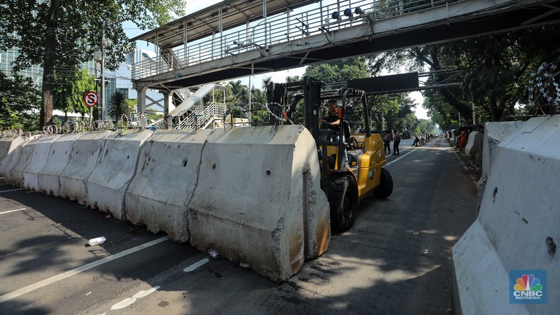 Petugas memindahkan barier beton menggunakan alat berat untuk penutupan ruas jalan di kawasan Jalan Medan Merdeka Barat, Jakarta, Kamis (6/6/2024). (CNBC Indonesia/Faisal Rahman)