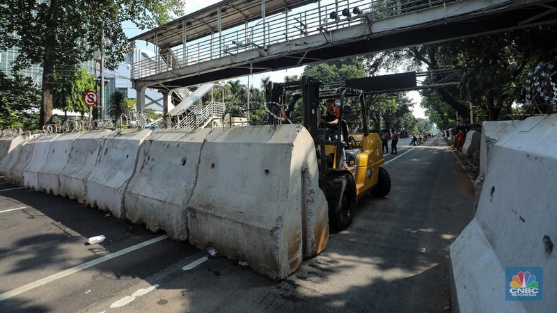 Petugas memindahkan barier beton menggunakan alat berat untuk penutupan ruas jalan di kawasan Jalan Medan Merdeka Barat, Jakarta, Kamis (6/6/2024). (CNBC Indonesia/Faisal Rahman)