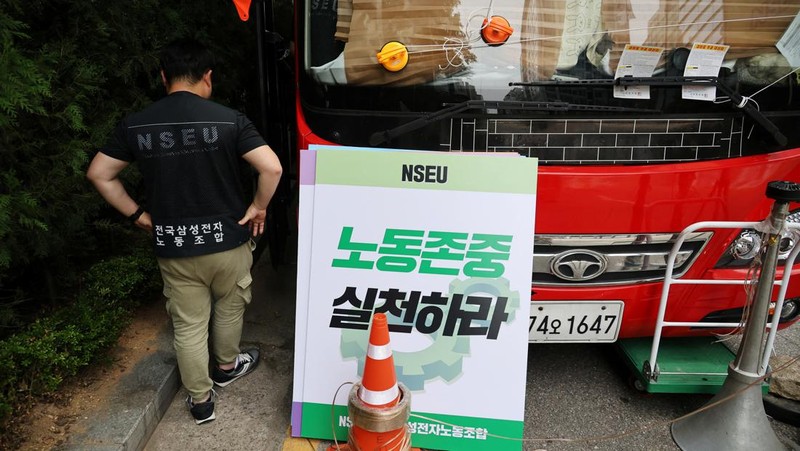 Members of National Samsung Electronics Union hold placards, which read 