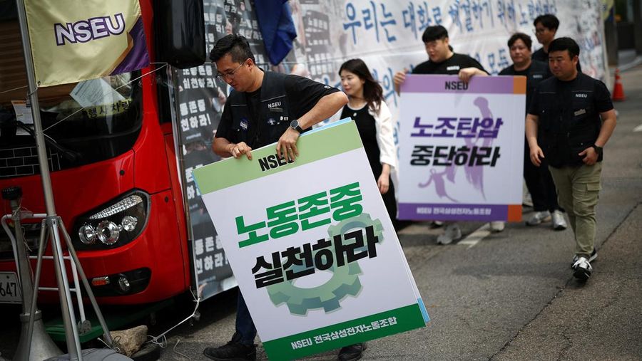 Members of National Samsung Electronics Union hold placards, which read 
