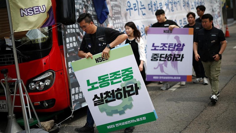 Members of National Samsung Electronics Union hold placards, which read 