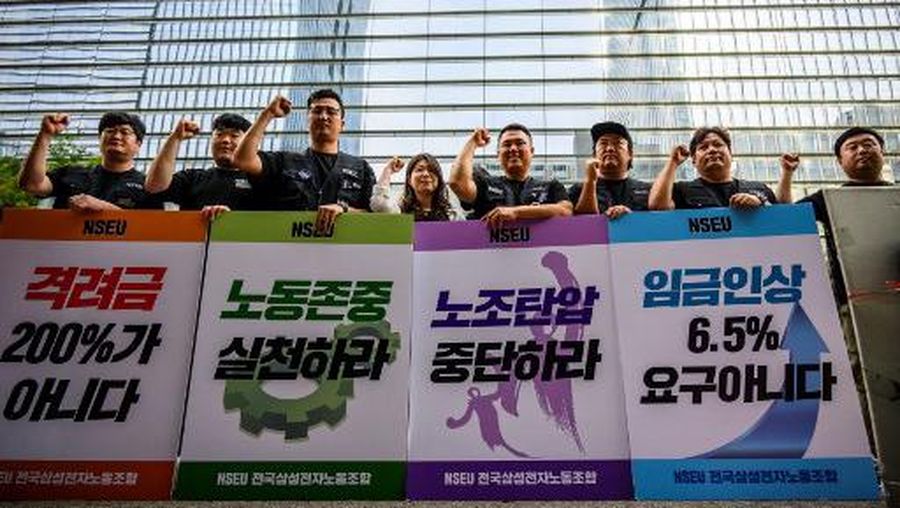 Samsung Electronics' union members hold placards during a rally outside the company building in Seoul on June 7, 2024, as workers at the tech giant staged the first ever strike, the head of a major union representing tens of thousands of people told AFP. (Photo by ANTHONY WALLACE / AFP)
