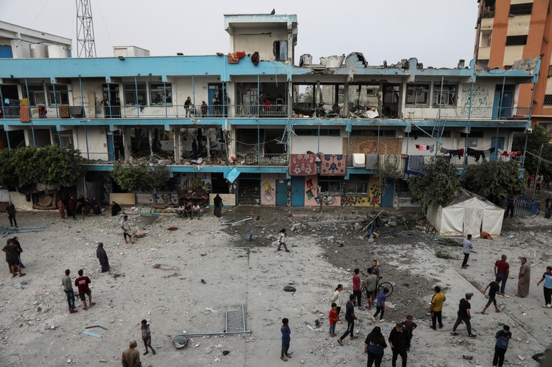 Warga Palestina memeriksa lokasi serangan Israel terhadap sekolah UNRWA yang menampung para pengungsi, di tengah konflik Israel-Hamas, di kamp pengungsi Nuseirat di Jalur Gaza tengah, 6 Juni 2024. (REUTERS/Abed Khaled)