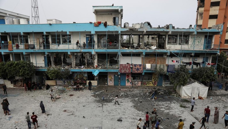 Warga Palestina memeriksa lokasi serangan Israel terhadap sekolah UNRWA yang menampung para pengungsi, di tengah konflik Israel-Hamas, di kamp pengungsi Nuseirat di Jalur Gaza tengah, 6 Juni 2024. (REUTERS/Abed Khaled)