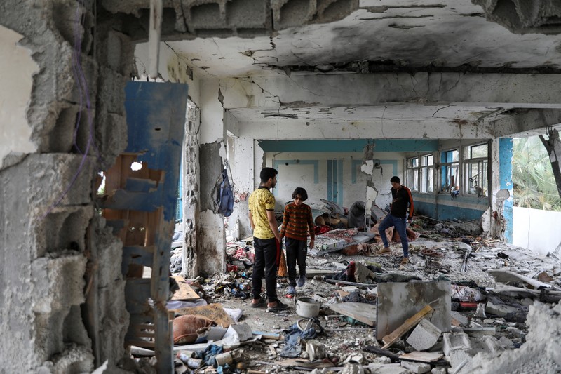 Warga Palestina memeriksa lokasi serangan Israel terhadap sekolah UNRWA yang menampung para pengungsi, di tengah konflik Israel-Hamas, di kamp pengungsi Nuseirat di Jalur Gaza tengah, 6 Juni 2024. (REUTERS/Abed Khaled)