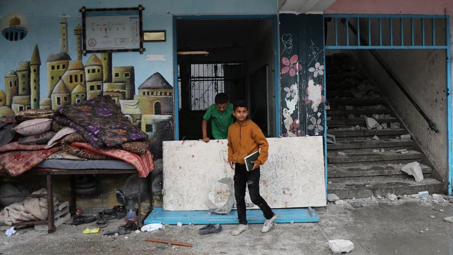 Warga Palestina memeriksa lokasi serangan Israel terhadap sekolah UNRWA yang menampung para pengungsi, di tengah konflik Israel-Hamas, di kamp pengungsi Nuseirat di Jalur Gaza tengah, 6 Juni 2024. (REUTERS/Abed Khaled)