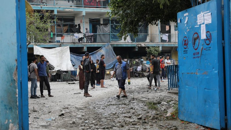 Warga Palestina memeriksa lokasi serangan Israel terhadap sekolah UNRWA yang menampung para pengungsi, di tengah konflik Israel-Hamas, di kamp pengungsi Nuseirat di Jalur Gaza tengah, 6 Juni 2024. (REUTERS/Abed Khaled)