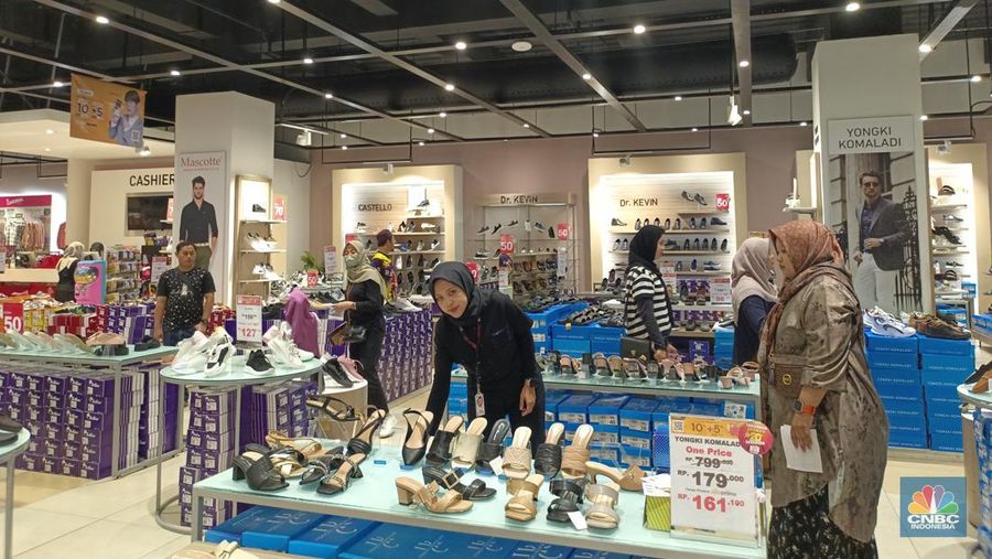 Sejumlah pengunjung melihat sepatu selama gebyar diskon besar-besaran hingga 50% + 20% di Transmart Full Day Sale kembali hadir hari ini, Minggu (9/6/2024). (CNBC Indonesia/Martyasari Rizky)