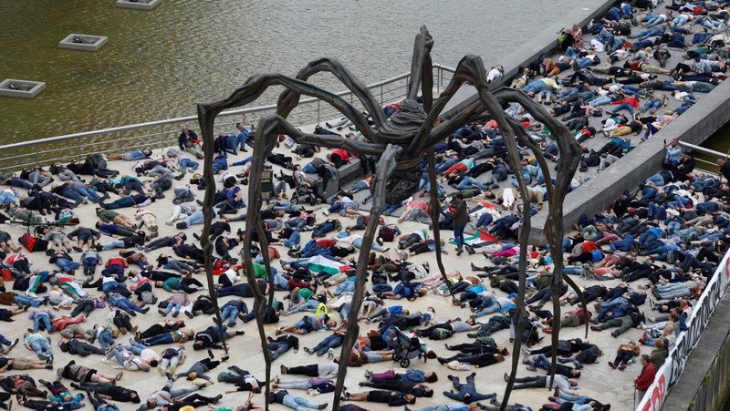 Para pengunjuk rasa berbaring di luar Museum seni modern Guggenheim Bilbao untuk meniru korban jiwa di Gaza, selama protes yang diselenggarakan oleh kolektif Gernika-Palestina dari wilayah Basque Spanyol, di tengah konflik Israel-Hamas, di Bilbao, Spanyol, 8 Juni. 2024. (REUTERS/Vincent West)