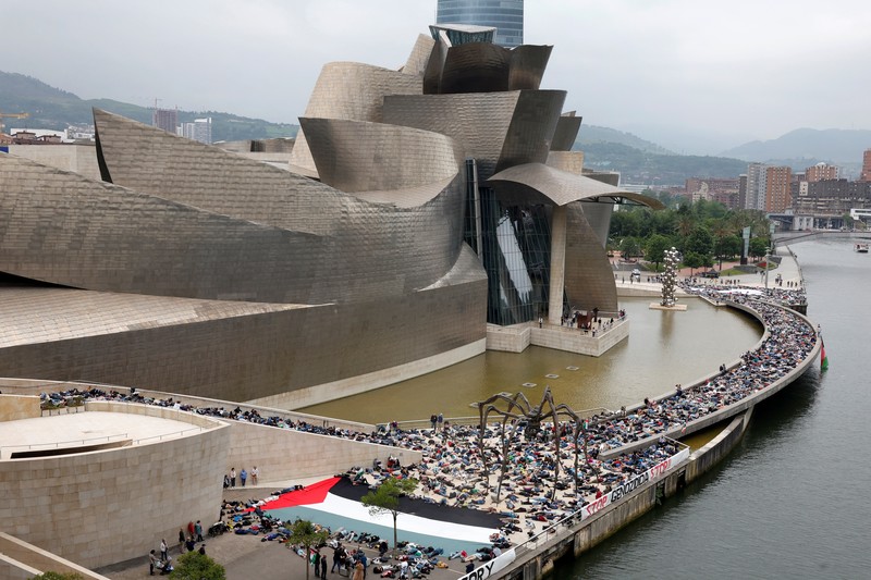Para pengunjuk rasa berbaring di luar Museum seni modern Guggenheim Bilbao untuk meniru korban jiwa di Gaza, selama protes yang diselenggarakan oleh kolektif Gernika-Palestina dari wilayah Basque Spanyol, di tengah konflik Israel-Hamas, di Bilbao, Spanyol, 8 Juni. 2024. (REUTERS/Vincent West)