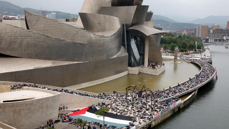 Para pengunjuk rasa berbaring di luar Museum seni modern Guggenheim Bilbao untuk meniru korban jiwa di Gaza, selama protes yang diselenggarakan oleh kolektif Gernika-Palestina dari wilayah Basque Spanyol, di tengah konflik Israel-Hamas, di Bilbao, Spanyol, 8 Juni. 2024. (REUTERS/Vincent West)