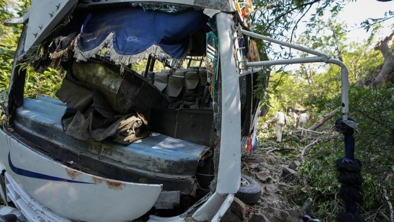 Petugas keamanan memeriksa sebuah bus yang jatuh ke jurang yang dalam pada hari Minggu setelah ditembaki oleh tersangka militan di distrik Reasi, Jammu dan Kashmir, Senin, 10 Juni 2024. Bus itu membawa peziarah ke base camp kuil Hindu yang terkenal itu Mata Vaishno Devi saat diserang menewaskan sedikitnya sembilan orang. (AP Photo/Channi Anand)