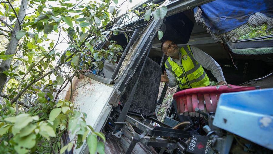 Petugas keamanan memeriksa sebuah bus yang jatuh ke jurang yang dalam pada hari Minggu setelah ditembaki oleh tersangka militan di distrik Reasi, Jammu dan Kashmir, Senin, 10 Juni 2024. Bus itu membawa peziarah ke base camp kuil Hindu yang terkenal itu Mata Vaishno Devi saat diserang menewaskan sedikitnya sembilan orang. (AP Photo/Channi Anand)