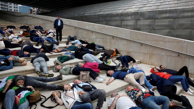 Para pengunjuk rasa berbaring di luar Museum seni modern Guggenheim Bilbao untuk meniru korban jiwa di Gaza, selama protes yang diselenggarakan oleh kolektif Gernika-Palestina dari wilayah Basque Spanyol, di tengah konflik Israel-Hamas, di Bilbao, Spanyol, 8 Juni. 2024. (REUTERS/Vincent West)