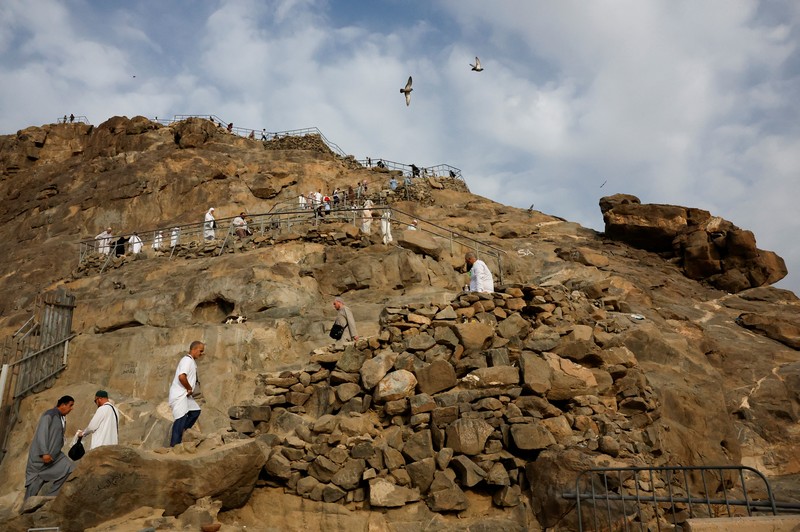 Peziarah Muslim mengunjungi Gunung Al-Noor, tempat umat Islam percaya Nabi Muhammad menerima kata-kata pertama Alquran melalui Jibril di gua Hira, menjelang ibadah haji tahunan di kota suci Mekah, Arab Saudi, 11 Juni 2024. (REUTERS/Mohammed Torokman)