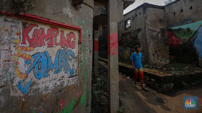 Seorang warga berjalan di dekat rumah yang rusak akibat sering terendam banjir di kawasan Cililitan, Jakarta, Selasa (11/6/2024). Seorang warga berjalan di dekat rumah yang rusak akibat sering terendam banjir di kawasan Cililitan, Jakarta, Selasa (11/6/2024). (CNBC Indonesia/Faisal Rahman)
