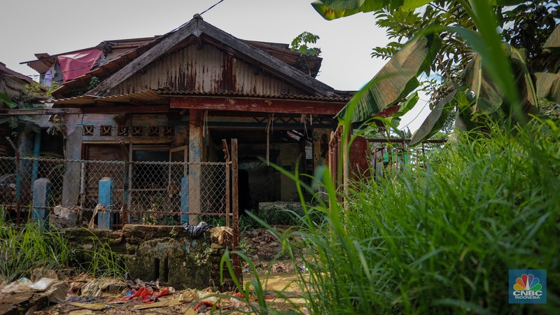 Seorang warga berjalan di dekat rumah yang rusak akibat sering terendam banjir di kawasan Cililitan, Jakarta, Selasa (11/6/2024). Seorang warga berjalan di dekat rumah yang rusak akibat sering terendam banjir di kawasan Cililitan, Jakarta, Selasa (11/6/2024). (CNBC Indonesia/Faisal Rahman)