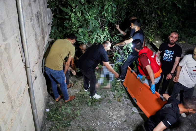 Seseorang berdiri di dekat kendaraan yang hancur, pasca serangan Israel, di Kafr Dan, dekat Jenin, di Tepi Barat yang diduduki Israel 11 Juni 2024. (REUTERS/Raneen Sawafta)
