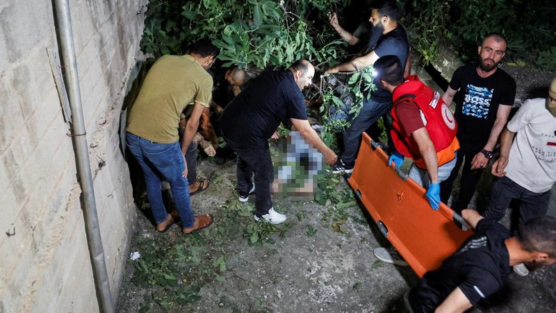 Seseorang berdiri di dekat kendaraan yang hancur, pasca serangan Israel, di Kafr Dan, dekat Jenin, di Tepi Barat yang diduduki Israel 11 Juni 2024. (REUTERS/Raneen Sawafta)