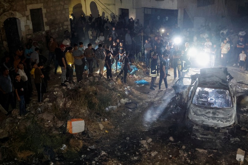 Seseorang berdiri di dekat kendaraan yang hancur, pasca serangan Israel, di Kafr Dan, dekat Jenin, di Tepi Barat yang diduduki Israel 11 Juni 2024. (REUTERS/Raneen Sawafta)