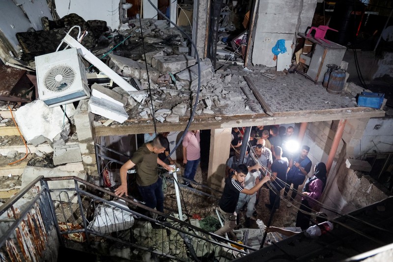 Seseorang berdiri di dekat kendaraan yang hancur, pasca serangan Israel, di Kafr Dan, dekat Jenin, di Tepi Barat yang diduduki Israel 11 Juni 2024. (REUTERS/Raneen Sawafta)