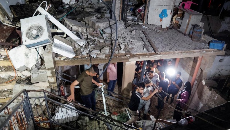 Seseorang berdiri di dekat kendaraan yang hancur, pasca serangan Israel, di Kafr Dan, dekat Jenin, di Tepi Barat yang diduduki Israel 11 Juni 2024. (REUTERS/Raneen Sawafta)